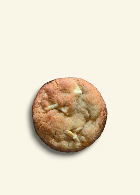 Cookie with white chocolate chips on a beige background