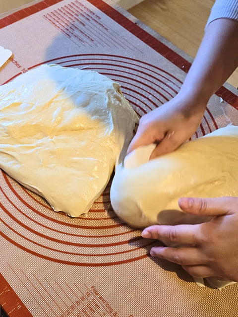 Person handling dough on a textured surface